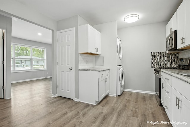 4420 Clearview Dr, Mchenry, IL 60050 - kitchen featuring appliances with stainless steel finishes, stacked washer and clothes dryer, backsplash, light wood-type flooring, and recessed lighting