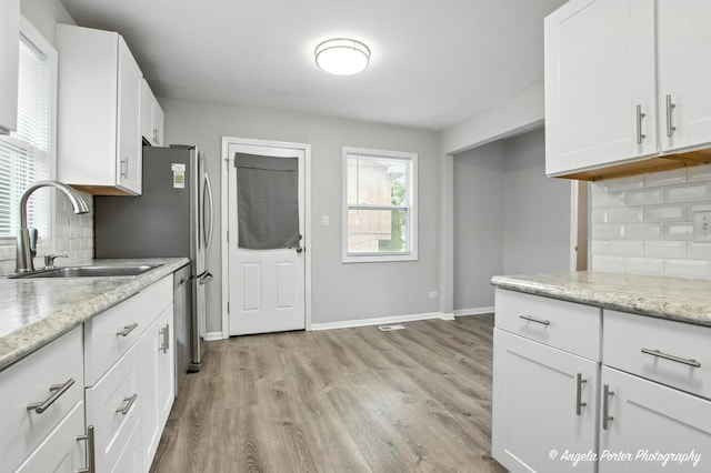 4420 Clearview Dr, Mchenry, IL 60050 - kitchen with tasteful backsplash, white cabinetry, light wood-type flooring, and light stone counters
