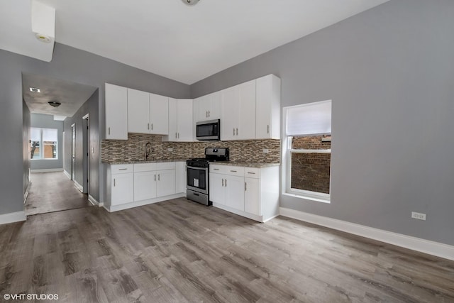 2345 S Lawndale Ave, Chicago, IL 60623 - kitchen featuring appliances with stainless steel finishes, stone counters, backsplash, and white cabinets