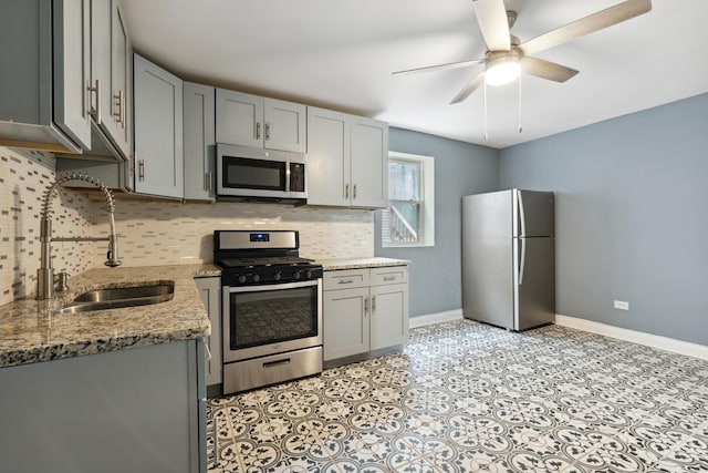 2345 S Lawndale Ave, Chicago, IL 60623 - kitchen featuring appliances with stainless steel finishes, gray cabinetry, decorative backsplash, a ceiling fan, and light stone counters