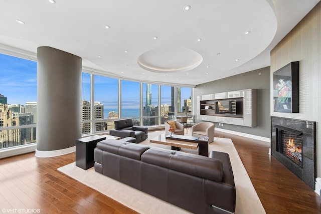 401 N Wabash St Unit 33A, Chicago, IL 60611 - living area with a view of skyline, a warm lit fireplace, a wall of windows, wood finished floors, and recessed lighting