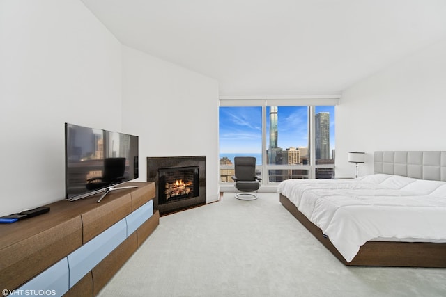 401 N Wabash St Unit 33A, Chicago, IL 60611 - bedroom with floor to ceiling windows, a warm lit fireplace, and carpet flooring