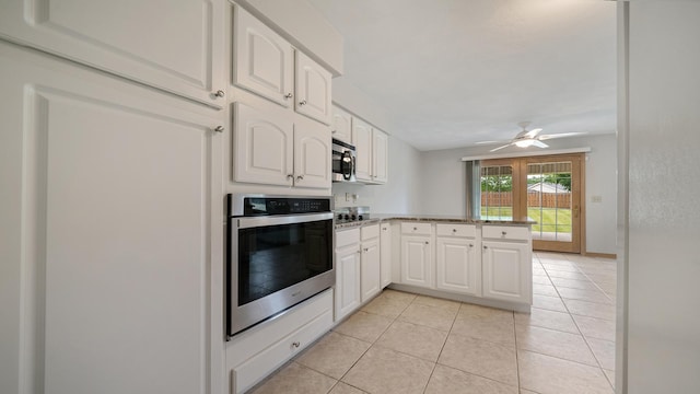 1126 Ingram Rd, Rockford, IL 61108 - kitchen with stainless steel appliances, a peninsula, white cabinets, light tile patterned flooring, and ceiling fan