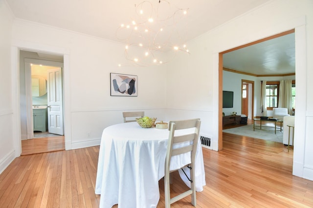 125 S Ridgeland Ave, Oak Park, IL 60302 - dining space featuring ornamental molding, light wood-type flooring, and a chandelier