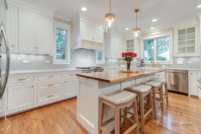 525 Meadow Ln, Libertyville, IL 60048 - kitchen with appliances with stainless steel finishes, wooden counters, white cabinets, backsplash, and crown molding