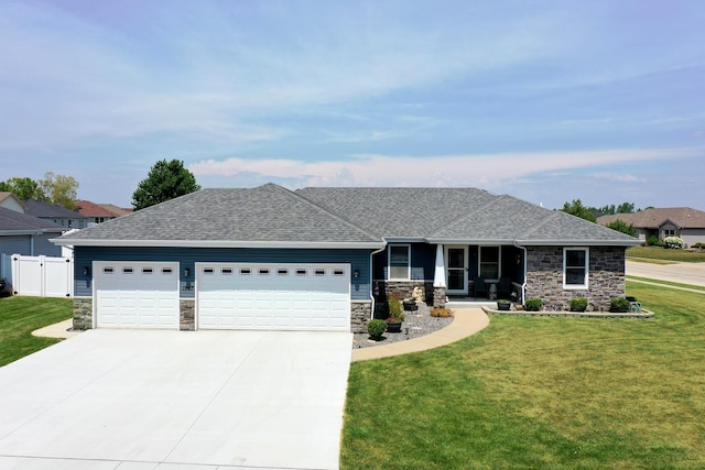 1867 Robert Dr, Bourbonnais, IL 60914 - view of front facade with stone siding, a garage, a shingled roof, concrete driveway, and covered porch