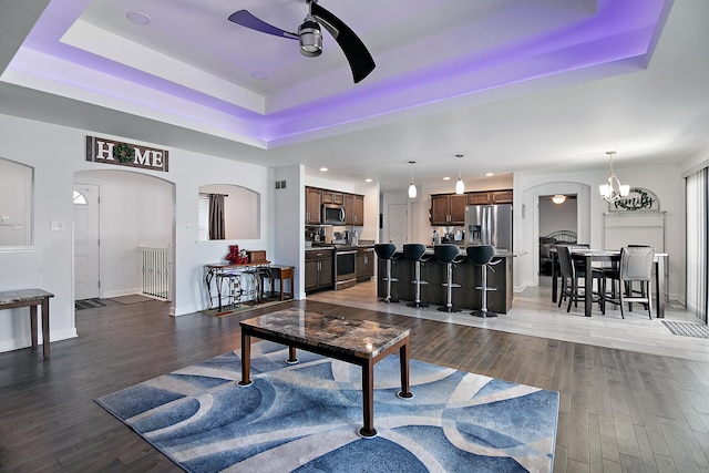 1867 Robert Dr, Bourbonnais, IL 60914 - living area featuring a ceiling fan, a tray ceiling, arched walkways, wood finished floors, and recessed lighting