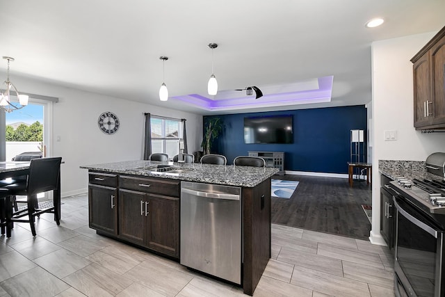 1867 Robert Dr, Bourbonnais, IL 60914 - kitchen with stainless steel appliances, a tray ceiling, dark stone countertops, healthy amount of natural light, and recessed lighting
