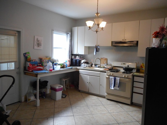 2820 W 36th St, Chicago, IL 60632 - kitchen featuring white range with gas stovetop, freestanding refrigerator, under cabinet range hood, and light countertops