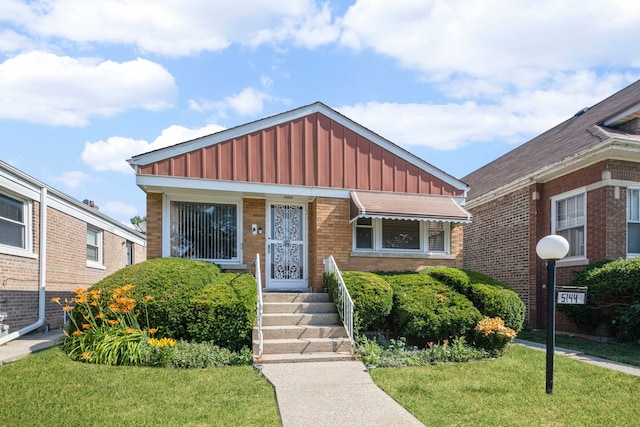 5144 W Saint Paul Ave, Chicago, IL 60639 - view of front of home featuring board and batten siding, a front lawn, and brick siding