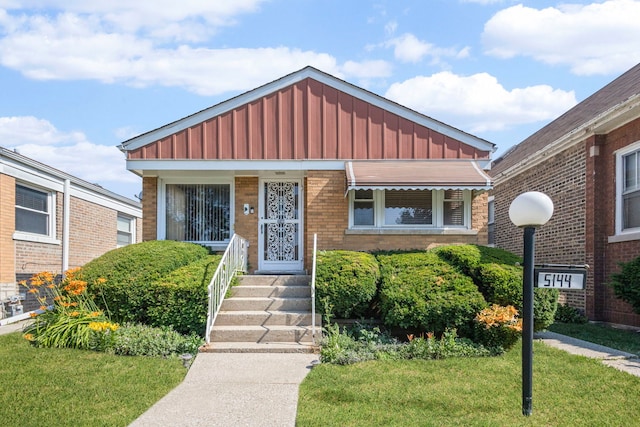 5144 W Saint Paul Ave, Chicago, IL 60639 - view of front of house featuring board and batten siding, brick siding, and a front yard