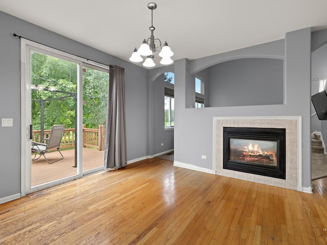 2019 Olde Mill Ln, Mchenry, IL 60050 - unfurnished living room featuring hardwood / wood-style floors, a chandelier, a fireplace, and arched walkways