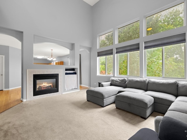 2019 Olde Mill Ln, Mchenry, IL 60050 - living room featuring a towering ceiling, carpet floors, a tiled fireplace, and arched walkways