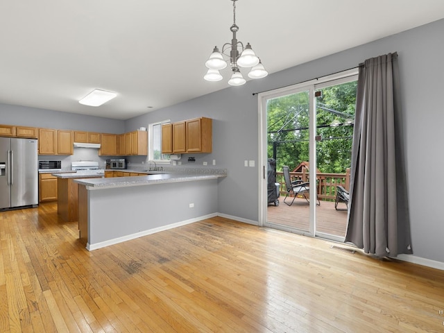 2019 Olde Mill Ln, Mchenry, IL 60050 - kitchen with stainless steel appliances, a chandelier, light countertops, light wood-style floors, and a peninsula