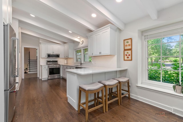 560 Golf Ln, Lake Forest, IL 60045 - kitchen featuring stainless steel appliances, a peninsula, dark wood finished floors, white cabinets, and light countertops