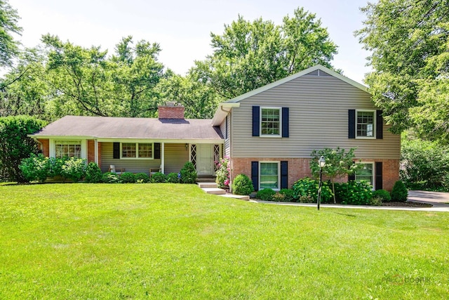 560 Golf Ln, Lake Forest, IL 60045 - split level home with a front yard, a chimney, brick siding, and covered porch