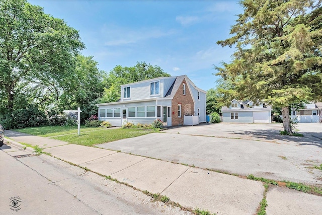 10730 S Ridgeland St, Worth, IL 60482 - view of front of home with a sunroom, driveway, brick siding, and a front yard