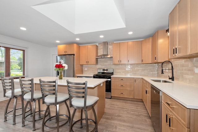 12123 S 72nd Ct, Palos Heights, IL 60463 - kitchen with stainless steel appliances, wall chimney range hood, a kitchen bar, a center island, and light wood-type flooring