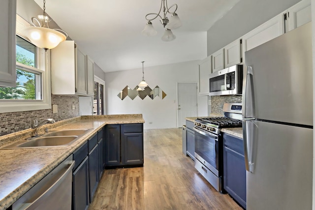 4113 Luckie Ct, Zion, IL 60099 - kitchen featuring appliances with stainless steel finishes, a chandelier, decorative backsplash, and light wood finished floors
