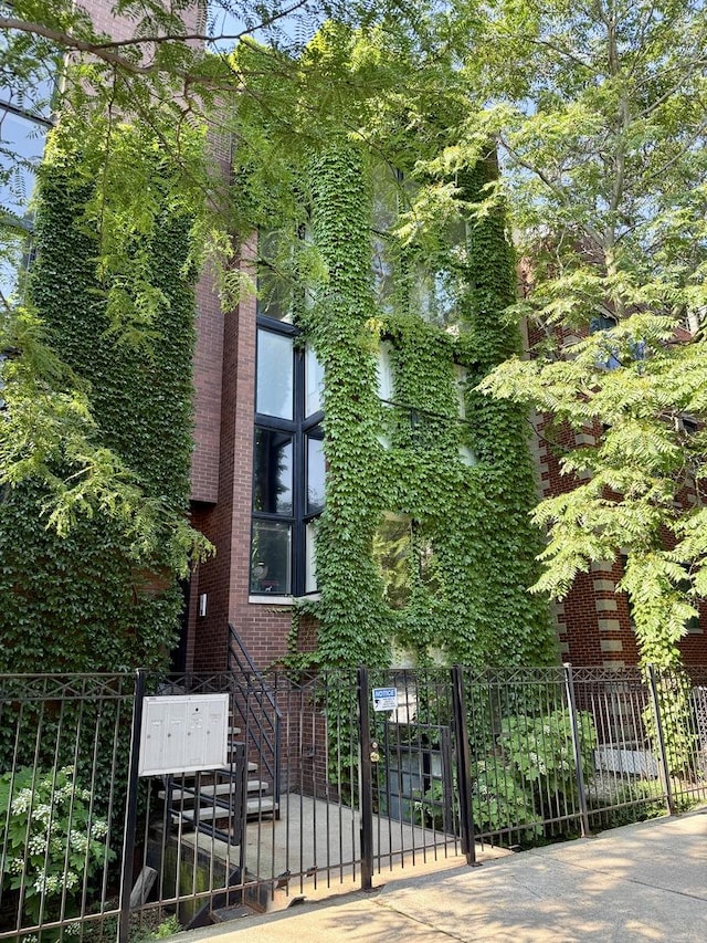 1621 W Le Moyne St Unit 1W, Chicago, IL 60622 - view of front of property featuring a fenced front yard, stairway, and brick siding