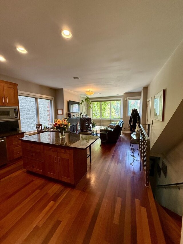 1621 W Le Moyne St Unit 1W, Chicago, IL 60622 - kitchen featuring stainless steel microwave, dark wood finished floors, open floor plan, a kitchen breakfast bar, and recessed lighting