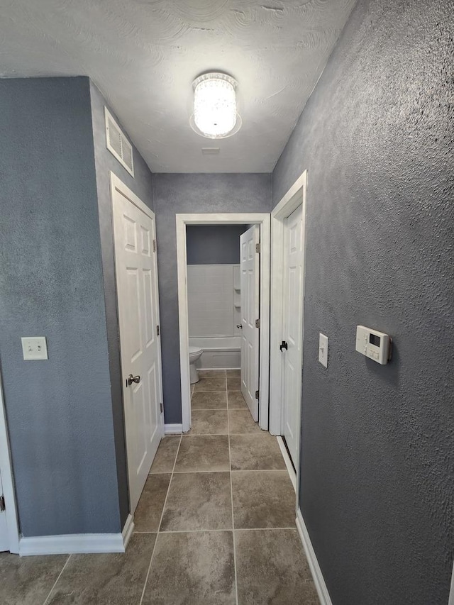 423 W Walnut Dr, Streamwood, IL 60107 - hall featuring a textured wall and dark tile patterned floors