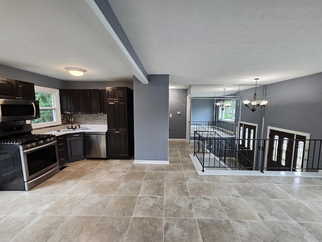 423 W Walnut Dr, Streamwood, IL 60107 - kitchen with appliances with stainless steel finishes, a chandelier, light countertops, pendant lighting, and decorative backsplash