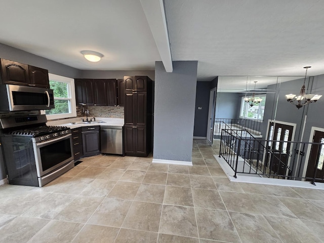 423 W Walnut Dr, Streamwood, IL 60107 - kitchen featuring appliances with stainless steel finishes, a chandelier, light countertops, dark brown cabinetry, and backsplash