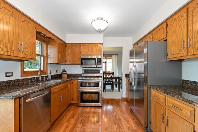 8648 Carriage Ln, Tinley Park, IL 60487 - kitchen with appliances with stainless steel finishes, dark wood-type flooring, brown cabinetry, and dark stone countertops