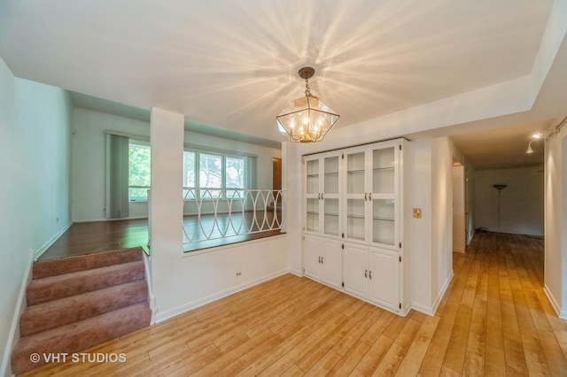 626 Barberry Rd, Highland Park, IL 60035 - unfurnished dining area featuring light wood-type flooring, a chandelier, and stairway