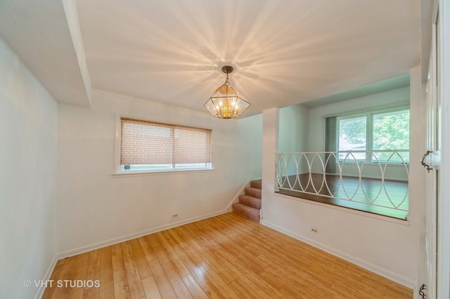 626 Barberry Rd, Highland Park, IL 60035 - empty room featuring wood-type flooring, a chandelier, and stairs