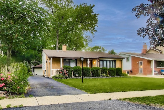 126 Oak Ave, Wood Dale, IL 60191 - view of front facade with a chimney, brick siding, a front yard, and covered porch