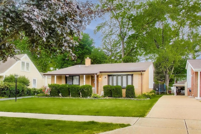 126 Oak Ave, Wood Dale, IL 60191 - view of front of house with brick siding, a trampoline, a front yard, and a chimney