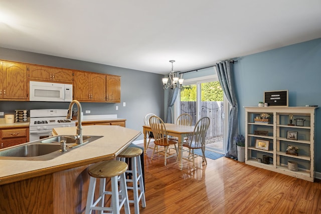 504 N Reef Rd, Lockport, IL 60441 - kitchen with white appliances, light wood finished floors, a chandelier, brown cabinetry, and pendant lighting