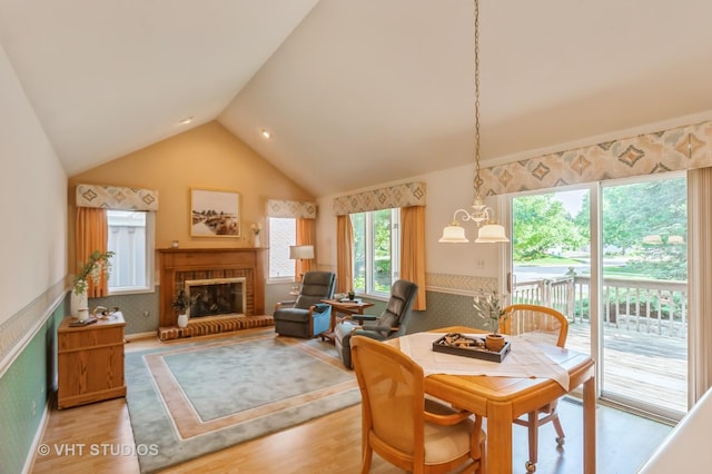 1808 N Normandy Ct, Arlington Heights, IL 60004 - dining room featuring a chandelier, a fireplace, light wood-type flooring, and high vaulted ceiling