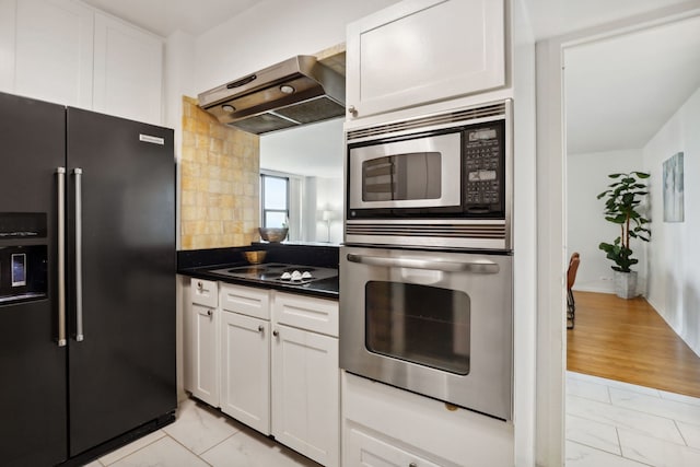 3150 N Lake Shore Dr Unit 8E, Chicago, IL 60657 - kitchen featuring appliances with stainless steel finishes, premium range hood, dark countertops, white cabinets, and backsplash