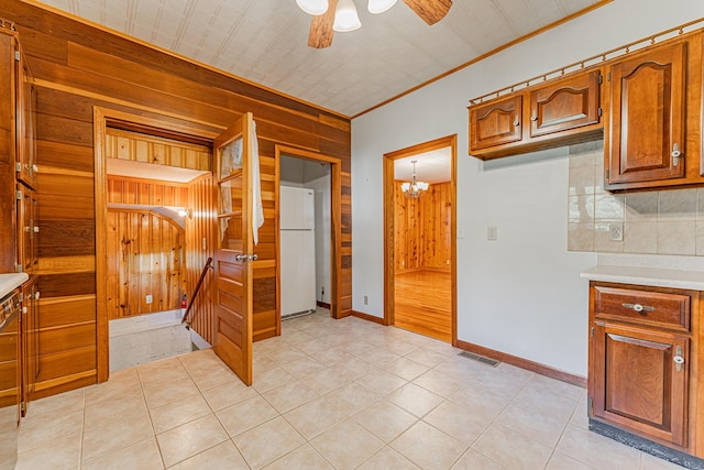102 S Oak St, Arrowsmith, IL 61722 - kitchen featuring freestanding refrigerator, wood walls, ceiling fan, crown molding, and brown cabinets