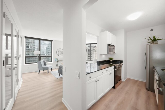 400 N Lasalle Dr Unit 2007, Chicago, IL 60654 - kitchen featuring appliances with stainless steel finishes, light wood-type flooring, white cabinetry, and dark countertops