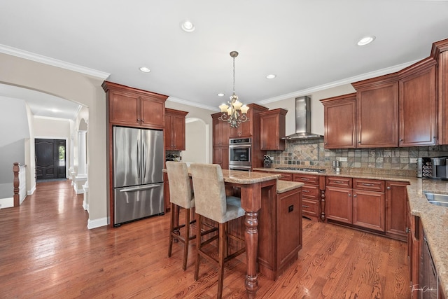 4037 Main St, Downers Grove, IL 60515 - kitchen featuring appliances with stainless steel finishes, wall chimney exhaust hood, arched walkways, wood finished floors, and recessed lighting
