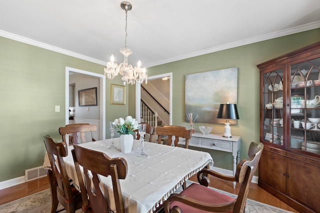 1014 Indian Rd, Glenview, IL 60025 - dining room with wood finished floors, a chandelier, crown molding, and stairway