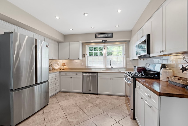 1014 Indian Rd, Glenview, IL 60025 - kitchen with appliances with stainless steel finishes, wood counters, decorative backsplash, white cabinets, and recessed lighting