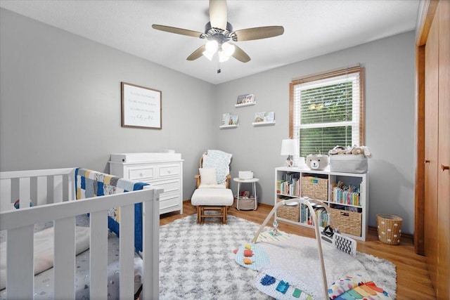 16 Rutherford Ct, Bloomington, IL 61705 - bedroom featuring a crib, wood finished floors, and a ceiling fan