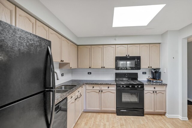 59 S Hale St Unit 402, Palatine, IL 60067 - kitchen featuring black appliances, light wood-type flooring, dark stone countertops, and a skylight