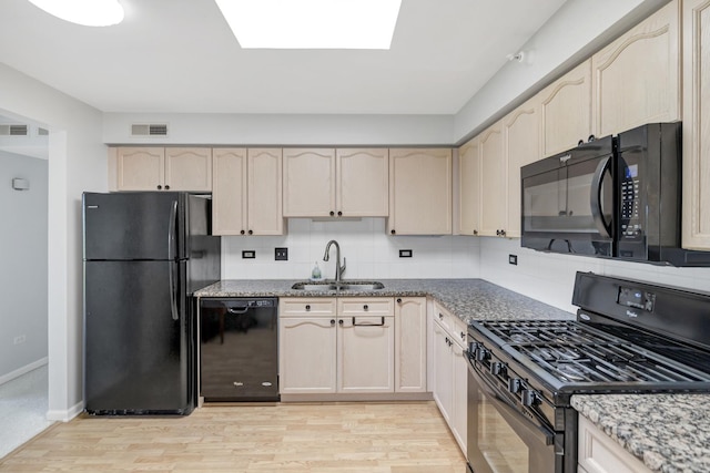 59 S Hale St Unit 402, Palatine, IL 60067 - kitchen featuring black appliances, light wood-style flooring, stone countertops, a skylight, and backsplash