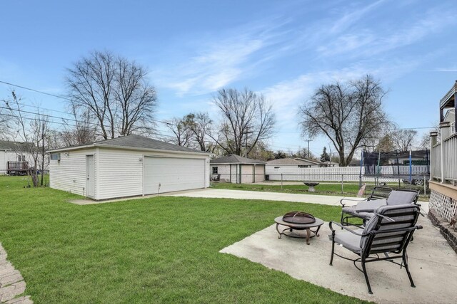 4445 Grove Ave, Stickney, IL 60402 - view of yard featuring a trampoline, a fire pit, an outbuilding, and a garage