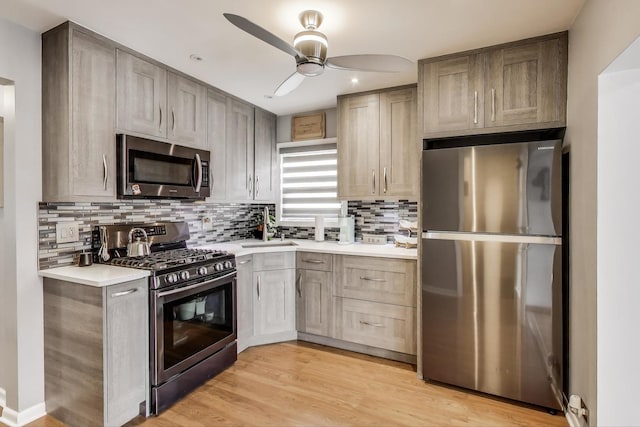 4445 Grove Ave, Stickney, IL 60402 - kitchen with appliances with stainless steel finishes, light countertops, ceiling fan, decorative backsplash, and light wood-style floors