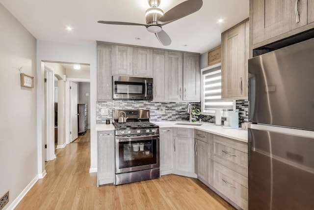 4445 Grove Ave, Stickney, IL 60402 - kitchen featuring stainless steel appliances, light countertops, decorative backsplash, a ceiling fan, and light wood-style floors