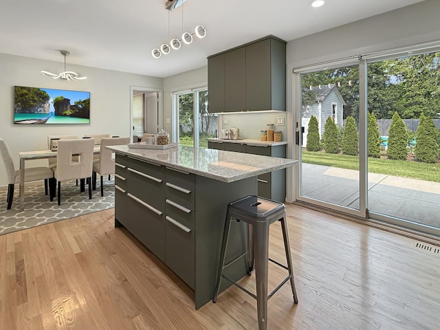 389 Forest Ave, Glen Ellyn, IL 60137 - kitchen featuring modern cabinets, a center island, light wood-style floors, hanging light fixtures, and recessed lighting