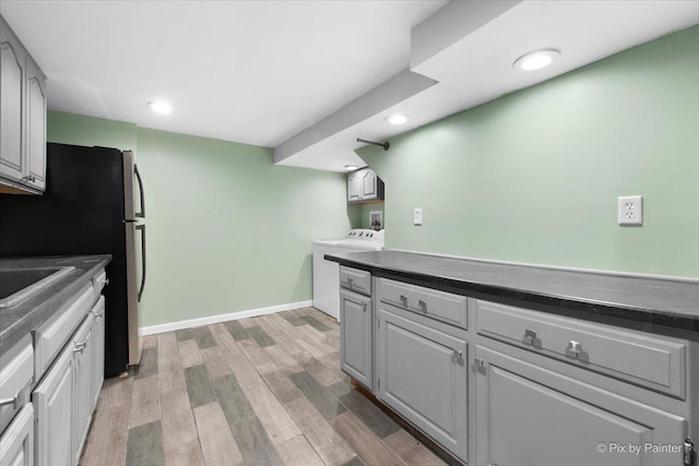 862 Arthur Dr, Elgin, IL 60120 - kitchen featuring washer / dryer, light wood-type flooring, dark countertops, recessed lighting, and freestanding refrigerator