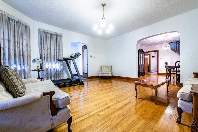 3124 N 77th Ct, Elmwood Park, IL 60707 - living area featuring arched walkways, a chandelier, light wood-style flooring, a textured ceiling, and crown molding